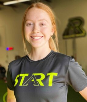 A smiling female athlete posing for a picture.
