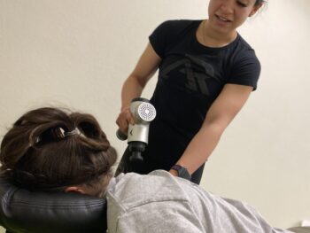 Athlete getting a massage with a massage gun.