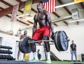 MMA athlete doing a squat with a trap bar.