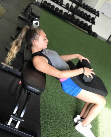 A female athlete doing a weighted hip bridge.