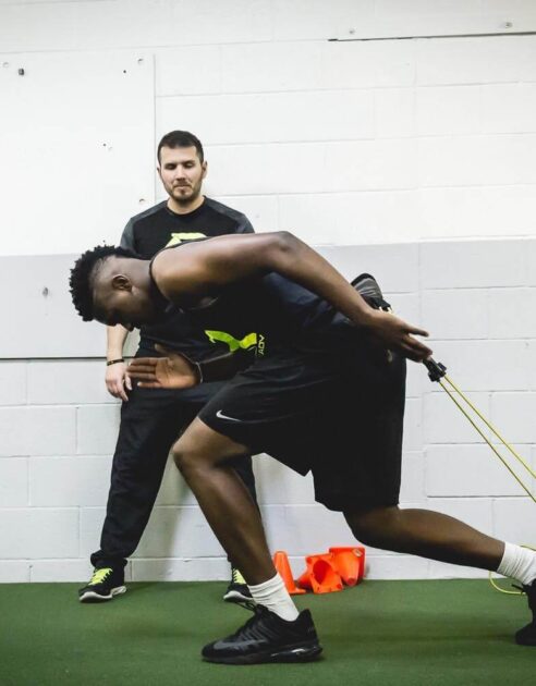 Athlete getting coaching on proper sprinting form.