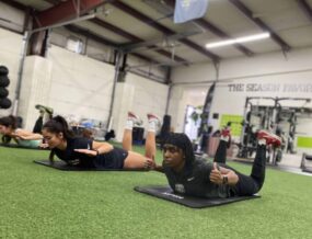 A group of athletes doing GOATA superman holds.